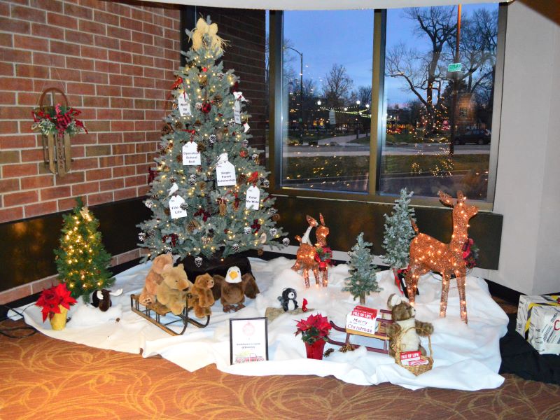 A Festival of Trees display in the Union Colony Civic Center lobby, featuring a winter scape with decorative animals and pine cones on the Christmas tree.