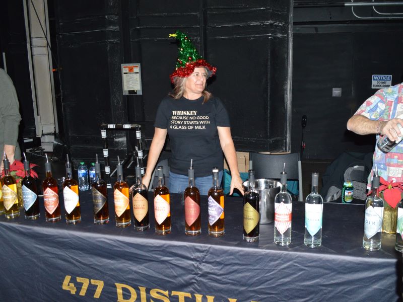 A vendor waiting for participants to taste whiskey selections at the Whiskey and Wonderland special event for Festival of Trees.