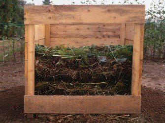 wooden box on dirt with compost pile inside
