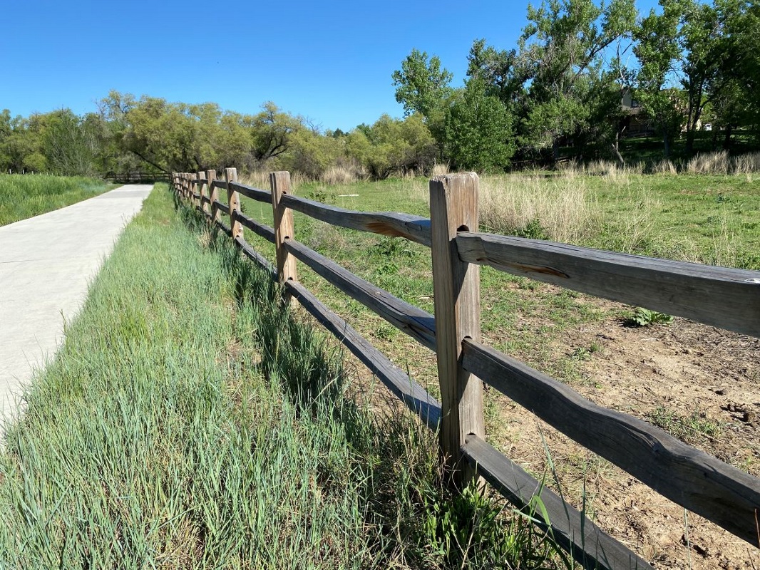 Concrete trail with wooden fence on one side