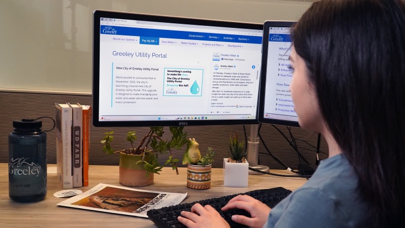 A woman reviews a webpage with information about the Greeley Utility Portal.
