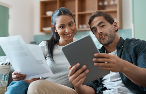 Young Hispanic couple viewing information on an iPad.