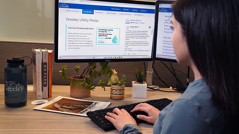 Woman using a keyboard to access the Greeley Utility Portal website