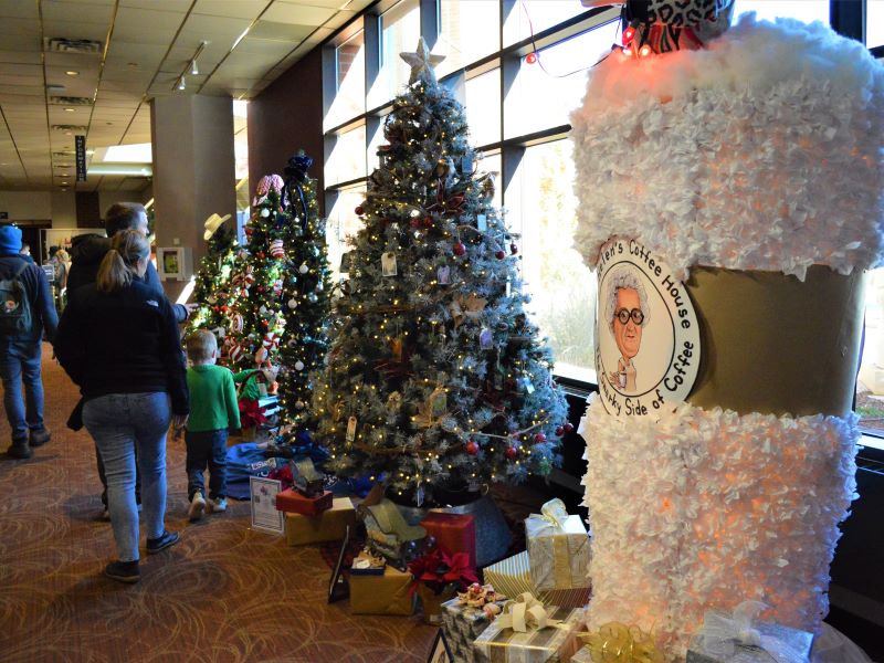 Visitors walking through the Union Colony Civic Center lobby viewing Festival of Tree displays including a tree designed as an Aunt Helen’s coffee cup.