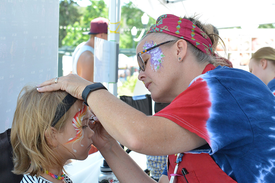 Photo of a young girl getting her face painted at the Greeley Arts Picnic