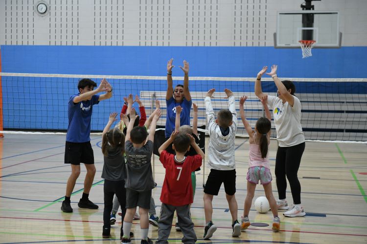 Volunteer coaches for recreation teaching kids volleyball