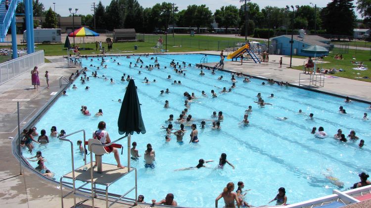 People swimming at the outdoor Centennial Pool in Greeley