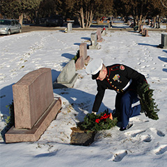 Veteran placing wreath on headstone