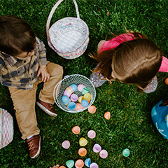 Kids Opening Easter Eggs While Sitting on Grass