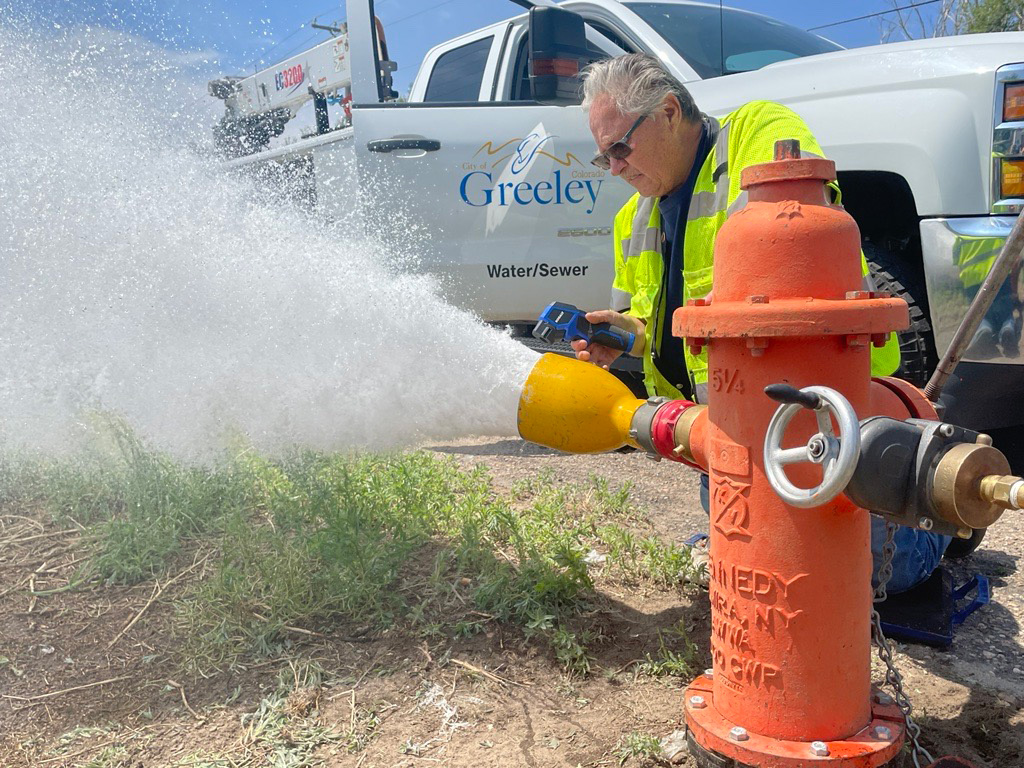 City worker flushing water out of a fire hydrant